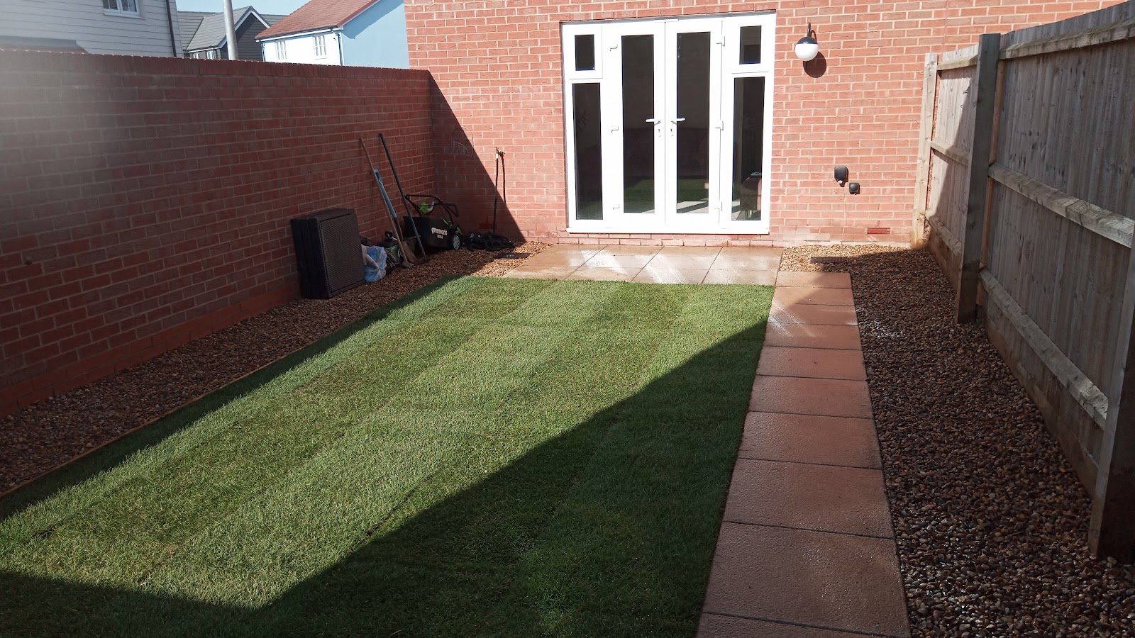 Rear garden with newly laid striped turf and gravel border