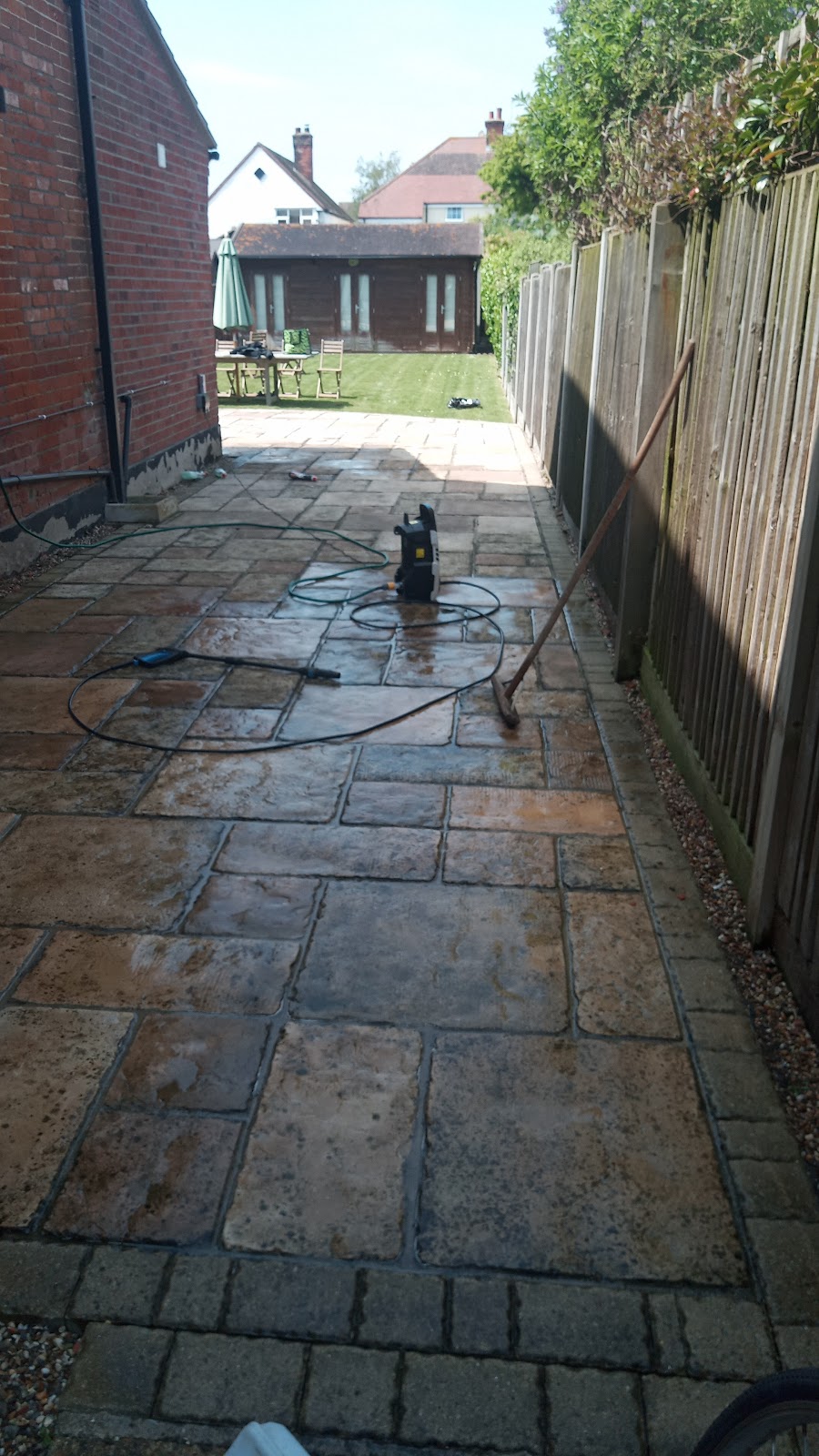 Patterned concrete drive being jet washed, half cleaned